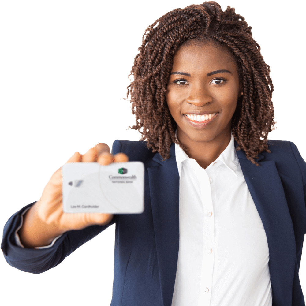 A smiling Black woman in a suit is holding up a Commonwealth Bank debit card.